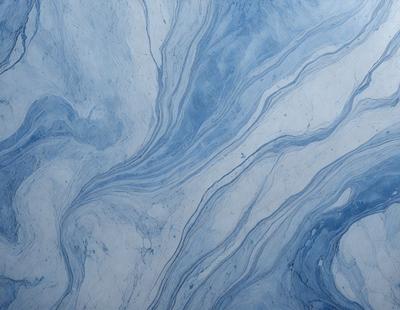 The primary subject of the image is a blue and white marbled tile. The setting is a wall with the tile as the main object. The visual style is a close-up of the tile, showcasing its intricate design. The dominant colors are blue and white, creating a calm and soothing atmosphere.