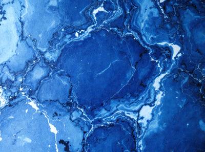 The primary subject of the image is a blue marble or stone, which is the main object, scene, or focus of the image. The setting or background features a blue and white marble or stone wall, which adds to the overall atmosphere of the image. The visual style of the image is a close-up of the blue marble or stone, showcasing its intricate details and textures. The colors and mood of the image are predominantly blue and white, creating a serene and calming atmosphere.