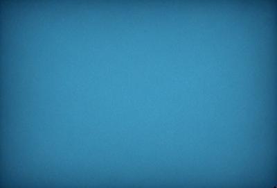 The primary subject of the image is a large, open, and empty blue sky. The setting is a vast, cloudless expanse, with no visible landmarks or objects. The visual style is a natural, untouched landscape, with no indication of digital manipulation or artistic elements. The colors and mood are predominantly blue, conveying a sense of tranquility and vastness.