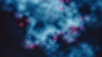 The primary subject of the image is a blue background with a pattern of red dots. The setting appears to be a night sky, with the dots possibly representing stars or other celestial objects. The visual style of the image is a combination of a photo and digital art, creating a unique and intriguing atmosphere. The colors and mood of the image are predominantly blue and red, with the red dots adding a touch of warmth and energy to the scene.