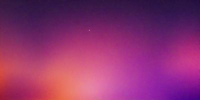 The primary subject of the image is a star, which is located in the middle of the scene. The setting is a purple sky, which creates a unique and visually striking backdrop. The visual style of the image is a photo, capturing the star and its surroundings in a natural and realistic manner. The colors and mood of the image are predominantly purple, giving it a serene and dreamy atmosphere.
