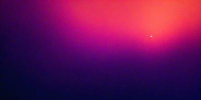 The primary subject of the image is a purple background. The setting is a dark, purple sky, which creates a moody atmosphere. The visual style is a photo, capturing the purple hue of the sky. The colors and mood of the image are predominantly purple, giving it a dramatic and intense appearance.