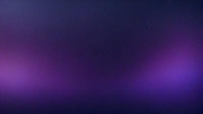 The primary subject of the image is a purple background. The setting is a dark, purple-colored space, which creates a moody atmosphere. The visual style appears to be a photo, as it captures the purple background in a realistic manner. The colors and mood of the image are predominantly purple, giving it a unique and striking appearance.