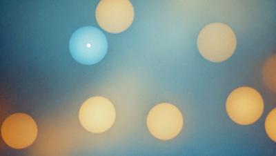 The primary subject of the image is a group of yellow circles, which are the main objects in the scene. The setting is a blue background, creating a contrasting color scheme. The visual style appears to be a digital art or illustration, as the circles are arranged in a pattern and the overall atmosphere is vibrant and lively.