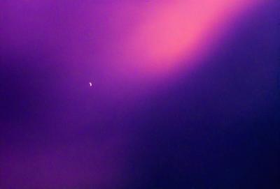 The primary subject of the image is a bright, pink-colored sky. The setting is a nighttime scene, with a moon visible in the sky. The visual style is a photo, capturing the beauty of the pink sky and the moon. The colors and mood of the image are vibrant and serene, creating a sense of wonder and tranquility.