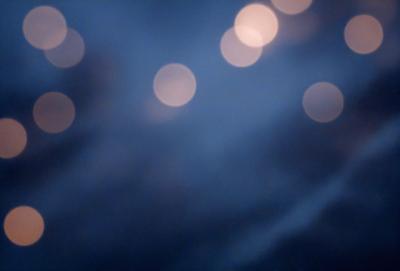 The primary subject of the image is a blue sky with a few white lights in the background. The setting appears to be a nighttime scene, with the lights creating a contrast against the dark sky. The visual style of the image is a photo, capturing the beauty of the night sky with the lights. The colors and mood of the image are predominantly dark and moody, with the white lights adding a touch of brightness to the scene.