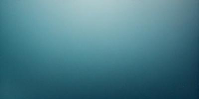 The primary subject of the image is a large body of water, which appears to be a deep blue ocean. The setting is a vast expanse of water, with no visible land or other objects in the background. The visual style of the image is a close-up of the water, showcasing its depth and beauty. The colors and mood of the image are predominantly blue, creating a serene and tranquil atmosphere.