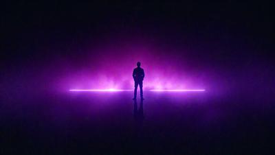 The primary subject of the image is a man standing in a purple-lit room. The setting appears to be a futuristic or industrial environment, with the man standing in front of a purple light. The visual style of the image is a photo, capturing the man's presence in the purple-lit room. The colors and mood of the image are predominantly purple, creating a mysterious and atmospheric ambiance.