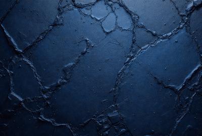 The primary subject of the image is a blue wall with a cracked and textured surface. The setting is a room with a blue background. The visual style is a close-up of the blue wall, showcasing its unique texture and appearance. The colors and mood of the image are predominantly blue, creating a calm and serene atmosphere.