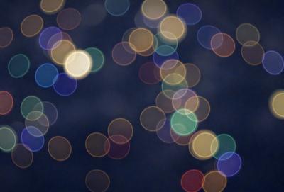 The primary subject of the image is a brightly lit, colorful background featuring a pattern of green and yellow circles. The setting appears to be a dark room, with the circles of light creating a visually striking and vibrant atmosphere. The visual style of the image is a combination of digital art and illustration, as the circles of light are created through a pattern of dots. The colors and mood of the image are predominantly green and yellow, with the circles of light creating a lively and energetic ambiance