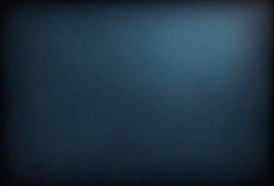 The primary subject of the image is a blue sky with no clouds. The setting is a dark blue background, which creates a contrast with the sky. The visual style is a photo, capturing the natural beauty of the sky. The colors and mood of the image are predominantly dark and moody, with the blue sky providing a sense of calmness and tranquility.