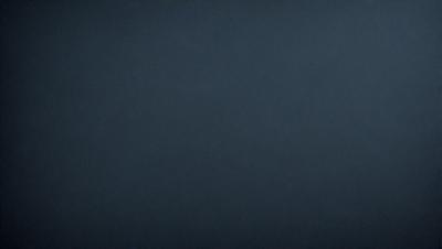 The primary subject of the image is a dark blue sky. The setting is a vast, open space with no visible landmarks or objects. The visual style is a simple, monochromatic image with no additional elements or textures. The colors and mood of the image are predominantly dark and moody, creating a sense of depth and vastness.