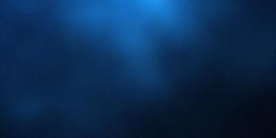 The primary subject of the image is a blue sky with a few clouds. The setting is a vast, open space, likely in the ocean. The visual style is a photo, capturing the beauty of the sky and clouds. The colors and mood are predominantly blue, creating a serene and peaceful atmosphere.