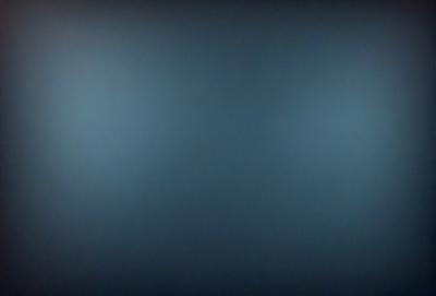 The primary subject of the image is a blue wall. The setting is a dark room with a blue background. The visual style is a photo, and the colors and mood are predominantly blue, creating a calm and serene atmosphere.