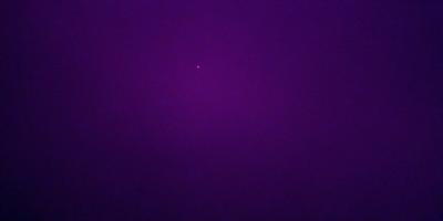The image is a purple background with a single star in the center. The star is the primary subject, and it stands out against the dark purple sky. The setting is a night sky, and the visual style is a simple, yet striking, design. The colors and mood of the image are predominantly purple, creating a calm and serene atmosphere.