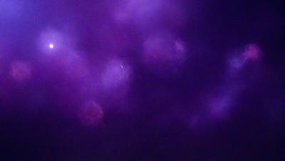 The image is a purple background with three white circles in the middle. The circles are arranged in a triangular shape, and they appear to be floating in the purple sky. The overall atmosphere of the image is serene and visually appealing.