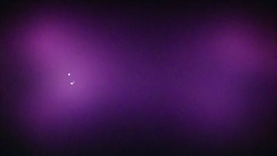 The image is a purple background with a single white dot in the center. The purple background creates a contrasting and visually striking scene. The white dot serves as the primary subject, drawing attention to itself in the otherwise dark and purple environment. The visual style of the image is a simple and minimalist design, with no additional elements or distractions. The colors and mood of the image are predominantly purple, creating a calm and serene atmosphere.