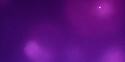 The primary subject of the image is the night sky, which is filled with stars. The setting is a purple background, creating a striking contrast with the stars. The visual style is a photo of the night sky, capturing the beauty of the celestial bodies. The colors and mood of the image are predominantly purple, creating a serene and peaceful atmosphere.