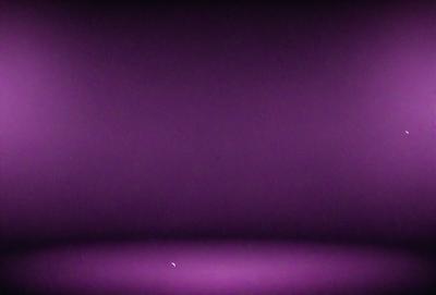The primary subject of the image is a purple wall. The setting is a dark room with a purple background. The visual style is a photo, and the dominant colors and overall atmosphere are purple and dark.