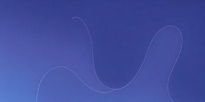 The primary subject of the image is a white string or yarn, which is the main focus of the image. The setting is a blue background, which creates a contrasting and visually appealing environment. The visual style of the image is a close-up of the white string, showcasing its texture and details. The colors and mood of the image are predominantly blue, giving it a calm and serene atmosphere.