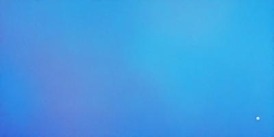 The primary subject of the image is a large, open, and empty blue sky. The setting is a vast, cloudless expanse, with no visible landmarks or objects. The visual style is a realistic representation of the sky, with no indication of digital manipulation or artistic elements. The colors and mood of the image are predominantly blue, conveying a sense of calmness and tranquility.