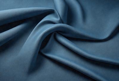 The primary subject of the image is a blue fabric, possibly a piece of cloth or a piece of a blanket. The setting is a dark background, which contrasts with the blue fabric. The visual style appears to be a close-up of the fabric, showcasing its texture and details. The colors and mood of the image are predominantly blue, creating a calm and serene atmosphere.