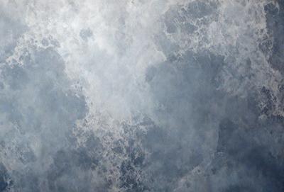 The primary subject of the image is a cloudy sky. The setting is a cloudy day, and the visual style is a photo. The colors and mood of the image are predominantly gray and moody, with the clouds creating a dramatic backdrop.