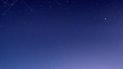 The primary subject of the image is the night sky, which is filled with stars. The setting is a dark, clear night with no clouds, creating a serene and peaceful atmosphere. The visual style is a photo, capturing the beauty of the night sky and the stars. The colors and mood are predominantly dark and tranquil, with the stars providing a sense of wonder and awe.