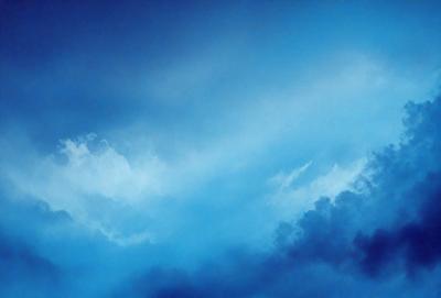 The primary subject of the image is a cloudy blue sky. The setting is a vast expanse of the sky, with no visible land or other objects. The visual style is a natural, outdoor scene. The dominant colors are blue and white, creating a calm and serene atmosphere.