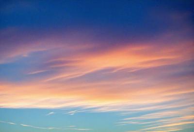 The primary subject of the image is a beautiful, colorful sky filled with clouds. The sky is a mix of pink, blue, and white hues, creating a serene and picturesque scene. The setting is a vast, open sky, with no visible land or buildings. The visual style of the image is a natural, outdoor scene, with no indication of digital manipulation or artistic elements. The colors and mood of the sky convey a sense of tranquility and awe, as the clouds float gracefully
