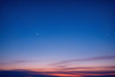 Primary subject: Moon
Setting/background: Sky
Visual style: Photo
Colors and mood: Blue and orange