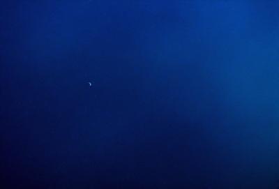 The primary subject of the image is the night sky, which is filled with stars. The setting is a dark, cloudless night, with no visible landmarks or objects. The visual style is a photo of the night sky, capturing the beauty of the stars and the vastness of the universe. The colors and mood of the image are serene and peaceful, as the night sky is illuminated by the stars and the darkness of the night.