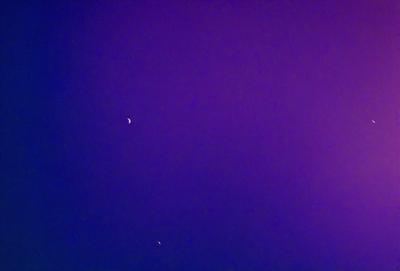 The primary subject of the image is the night sky, which is filled with stars. The setting is a dark, purple background that contrasts with the bright stars. The visual style is a photo of the night sky, capturing the beauty of the celestial bodies. The colors and mood of the image are predominantly purple, creating a serene and peaceful atmosphere.