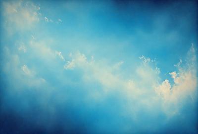 The primary subject of the image is a cloudy blue sky. The setting is a vast expanse of the sky, with no visible land or other objects. The visual style is a natural, outdoor scene. The colors and mood are predominantly blue, with a slightly overcast atmosphere.