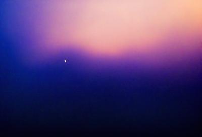 The primary subject of the image is a bright star in the night sky. The setting is a dark, cloudy sky, with the star being the main focus of the image. The visual style is a photo, capturing the beauty of the night sky and the star. The colors and mood of the image are dominated by the dark, cloudy sky and the bright star, creating a serene and peaceful atmosphere.