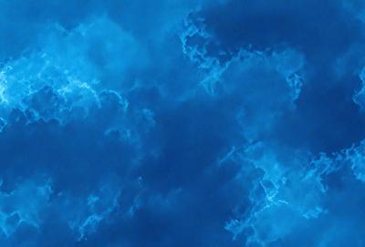 The primary subject of the image is a cloudy blue sky. The setting is a cloudy day with a blue sky, and the visual style is a natural, outdoor scene. The colors and mood of the image are predominantly blue, creating a calm and serene atmosphere.
