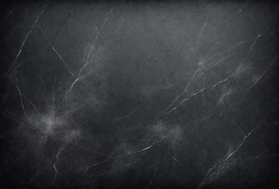 The primary subject of the image is a close-up of a grey stone wall. The setting is a stone wall, and the visual style is a photo. The dominant colors are grey and black, creating a moody atmosphere.
