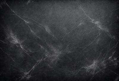 The primary subject of the image is a black and white marble wall. The setting is a dark room, and the visual style is a close-up of the marble wall. The colors and mood of the image are predominantly dark and moody, with the marble wall being the main focus.