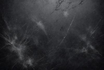 The primary subject of the image is a black background with a few white streaks. The setting is a dark room, and the visual style is a black and white photo. The colors and mood of the image are predominantly dark and moody, with the white streaks adding a touch of contrast.