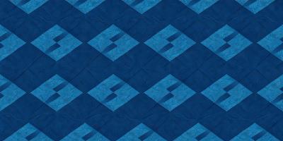 The primary subject of the image is a blue and white quilt with a geometric pattern. The setting is a blue background, and the visual style is a close-up of the quilt. The colors and mood of the image are predominantly blue and white, creating a calm and serene atmosphere.