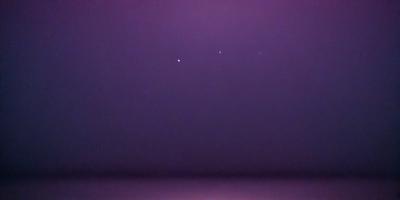 The primary subject of the image is the night sky, which is filled with stars. The setting is a dark, star-filled sky, and the visual style is a photo. The colors and mood of the image are predominantly dark and serene, with the stars providing a sense of depth and beauty.