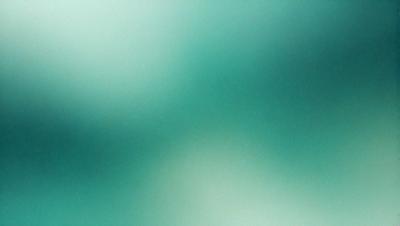 The primary subject of the image is a green background with a blurry, out-of-focus appearance. The setting is a green environment, and the visual style is a blurry, out-of-focus image. The colors and mood of the image are predominantly green, creating a calm and serene atmosphere.