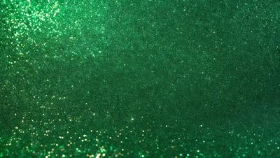 The primary subject of the image is a close-up of a green background with a pattern of glittering, shiny, and sparkling green and gold colors. The setting appears to be a dark room, and the visual style is a combination of a photo and digital art. The colors and mood of the image are vibrant, lively, and energetic, creating a captivating and eye-catching scene.
