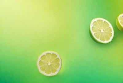 The primary subject of the image is a close-up of two slices of lemon on a green background. The lemon slices are placed on a green surface, which could be a table or a countertop. The visual style of the image is a photo, capturing the details of the lemon slices and the green background. The colors and mood of the image are predominantly green, with the lemon slices adding a touch of brightness and freshness to the scene.