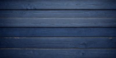 The primary subject of the image is a wooden wall with a blue color. The setting is a room with a blue wall, and the visual style is a photo. The dominant colors are blue and brown, creating a calm and soothing atmosphere.