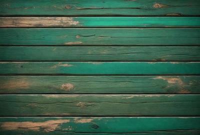 The primary subject of the image is a wooden wall with a green color. The setting is a room with a wooden floor. The visual style is a photo of a wooden wall. The dominant colors are green and brown, creating a warm and natural atmosphere.