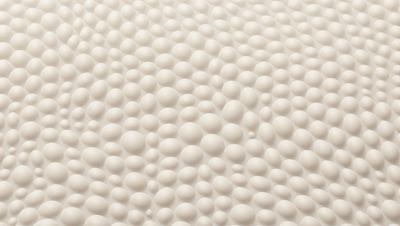 The primary subject of the image is a large, white, round ball. The setting is a white background, which creates a clean and minimalist appearance. The visual style is a close-up of the white ball, emphasizing its shape and texture. The colors and mood of the image are predominantly white, giving it a calm and serene atmosphere.