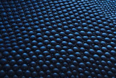The primary subject of the image is a close-up of a blue surface with a pattern of black balls. The setting appears to be a dark room, and the visual style is a combination of a photo and a digital artwork. The dominant colors are blue and black, creating a moody atmosphere.
