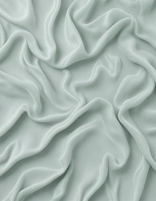 The primary subject of the image is a close-up of a blue fabric, possibly a piece of silk, with a wavy texture. The setting is a wall, and the visual style appears to be a photo. The dominant colors are blue and white, creating a calm and soothing atmosphere.