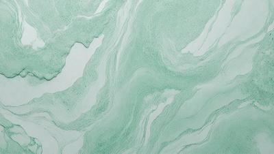 The image features a green and white marbled surface, which appears to be a wall or a countertop. The marbled pattern creates a visually appealing and textured appearance. The primary subject of the image is the marbled surface, which serves as the main focus of the image. The setting or background is the marbled surface, and the visual style is a close-up of the marbled pattern. The colors and mood of the image are predominantly green and white, giving it a clean and fresh appearance.
